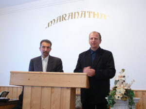 Gabor (left) shares his testimony in Hungarian, while it is translated into Romanian by the man on the right.